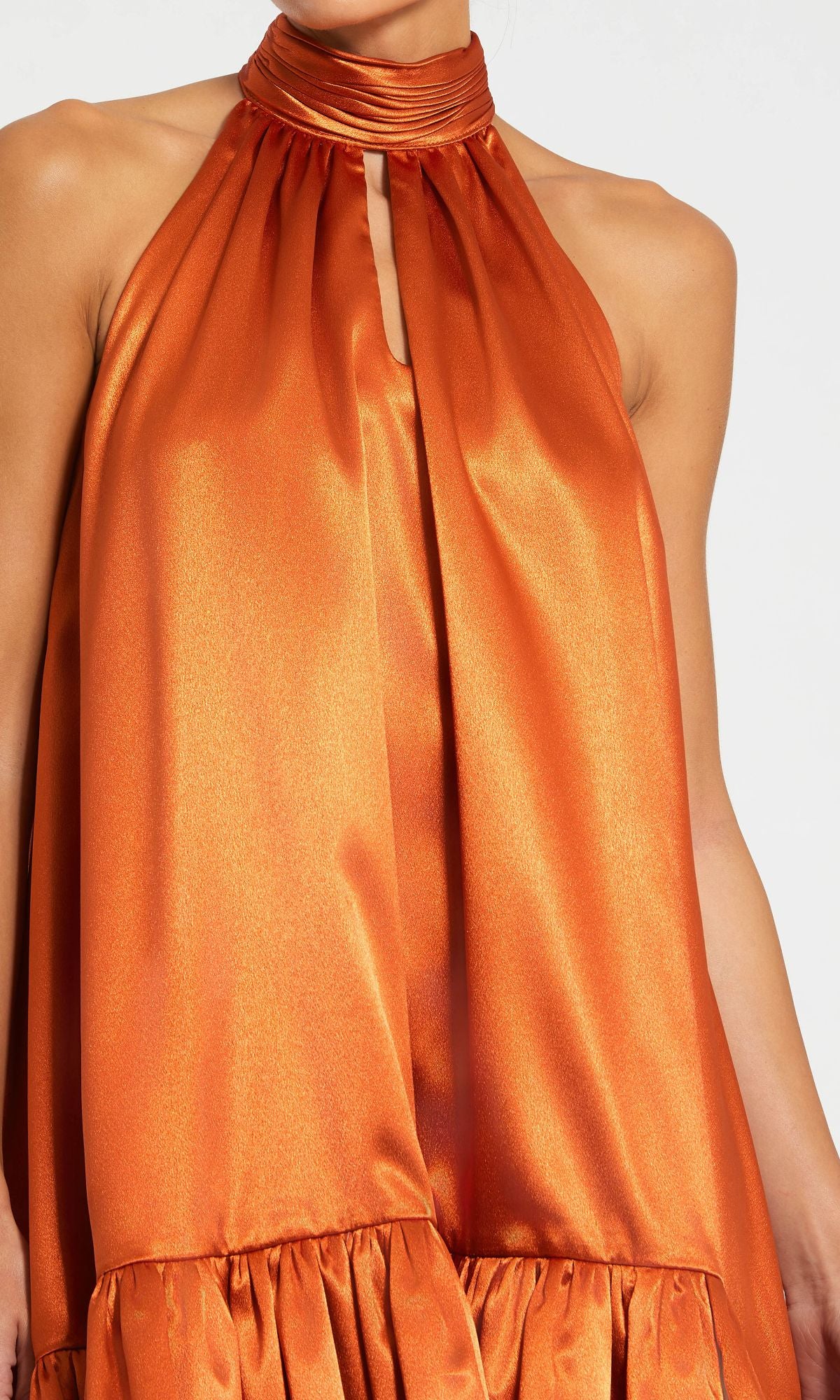 A person wearing the Mac Duggal 20711 Satin Wedding Guest Dress featuring a shiny orange satin finish, high neck, gathered neckline, and a ruffled high-low hemline.
